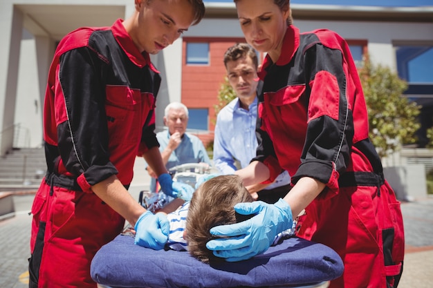 Paramedici die gewonde jongen onderzoeken