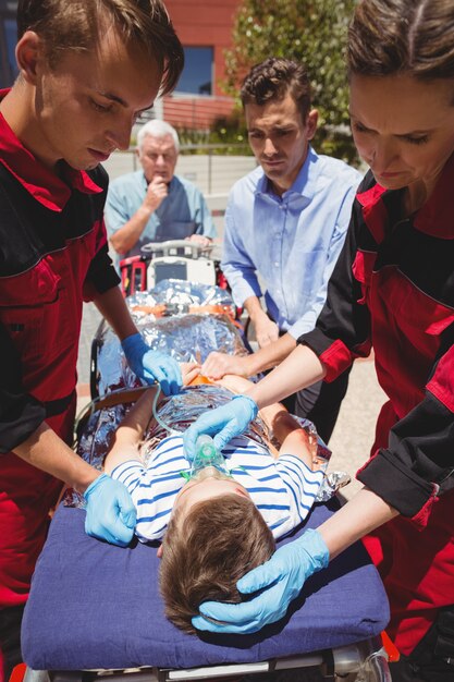 Paramedici die gewonde jongen onderzoeken