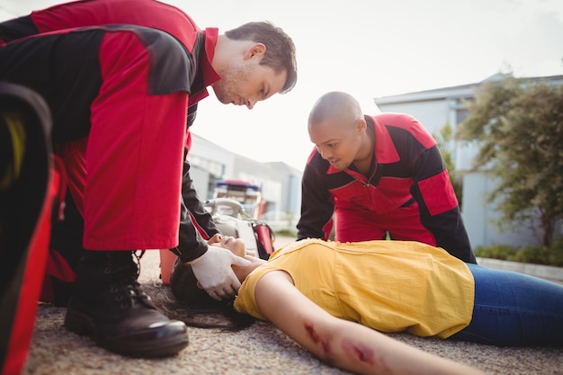 Gratis foto paramedici die gewonde vrouw onderzoeken