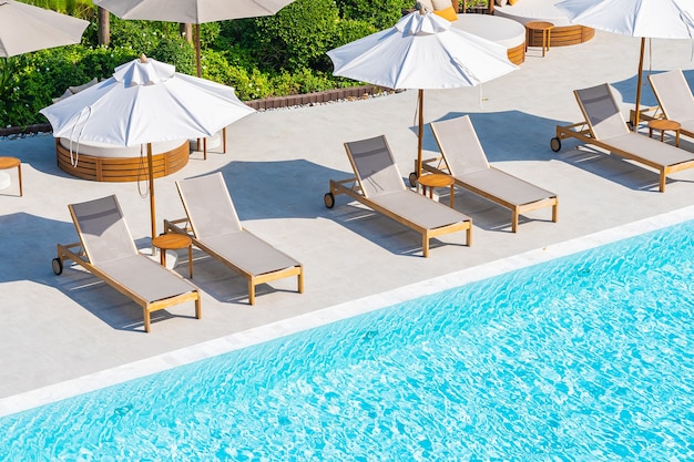 Parasol en ligstoel rond buitenzwembad in hotel resort bijna zee strand oceaan