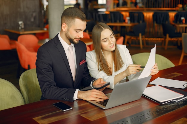 Partners zitten aan de tafel en werken in een café