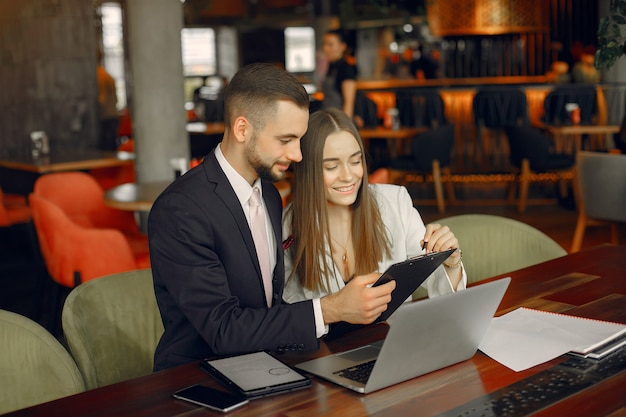 Partners zitten aan de tafel en werken in een café