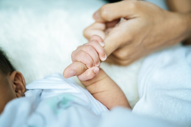 Pasgeboren baby hand in hand moeder