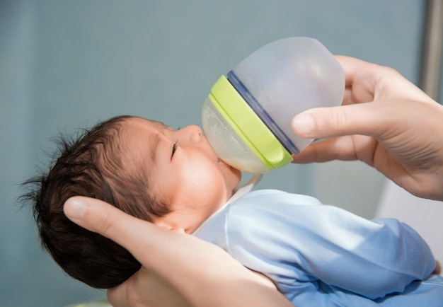 Pasgeboren baby wordt gevoed uit een klein flesje in het ziekenhuis