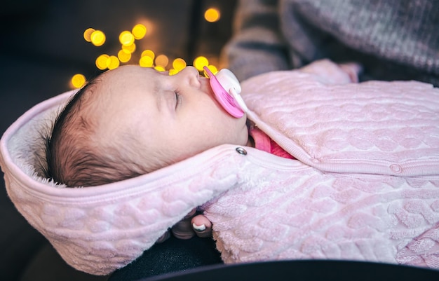 Pasgeboren babymeisje met fopspeen op onscherpe achtergrond met bokeh