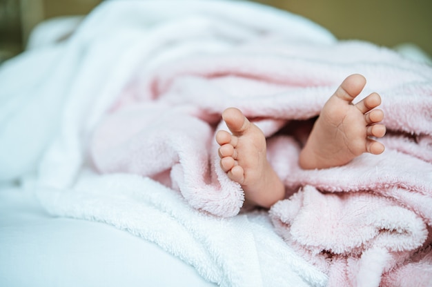 Pasgeboren babyvoeten op een witte deken