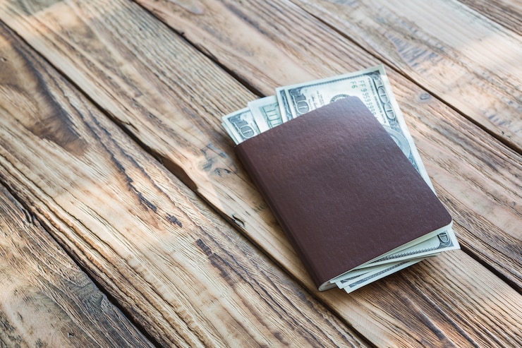 Gratis Foto paspoort met geld op houten planken