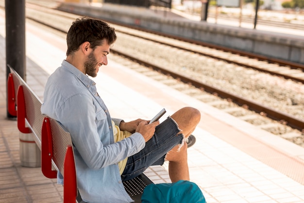 Passagier die op trein op een bank wacht