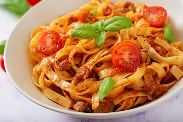 Pasta Fettuccine Bolognese met tomatensaus in witte kom.