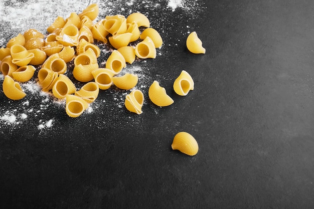 Pasta geïsoleerd op achtergrond bedekt met bloem.