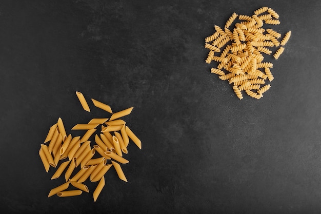 Pasta geïsoleerd op zwarte achtergrond in tegenovergestelde hoeken.