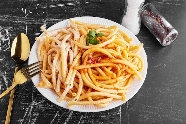 Pasta in tomatensaus in een witte plaat.