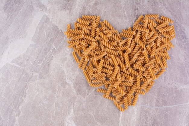 Pasta op een marmeren ondergrond in hartvorm