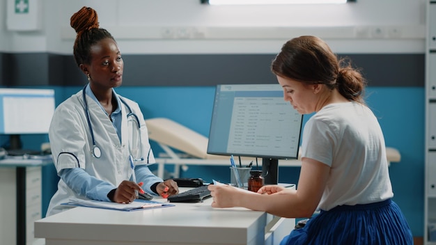 Patiënt die medische behandeling krijgt van arts bij controlebezoek. Dokter die fles pillen en receptpapier voor medicijnen tegen ziekte geeft aan volwassene. Specialist medicatie geven