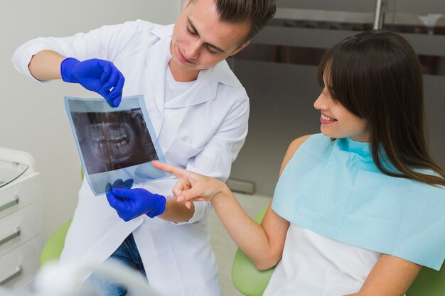 Patiënt wijzend op radiografie op tandarts