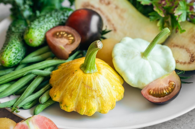 Gratis foto patissons tomaten, komkommers en sperziebonen close-up op een bord