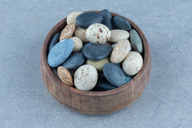 Pebble stenen snoepjes in een kom, op de marmeren tafel.