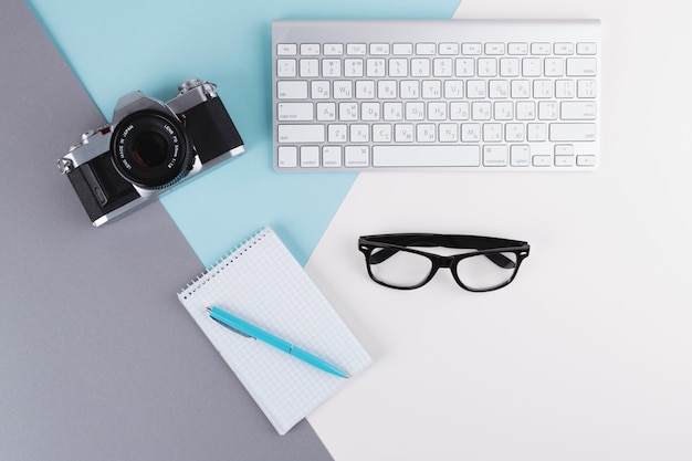 Gratis foto pen in de buurt van notebook, camera, bril en toetsenbord