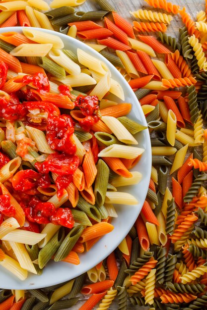 Penne pasta met saus, tomaat in een plaat op verspreide pasta