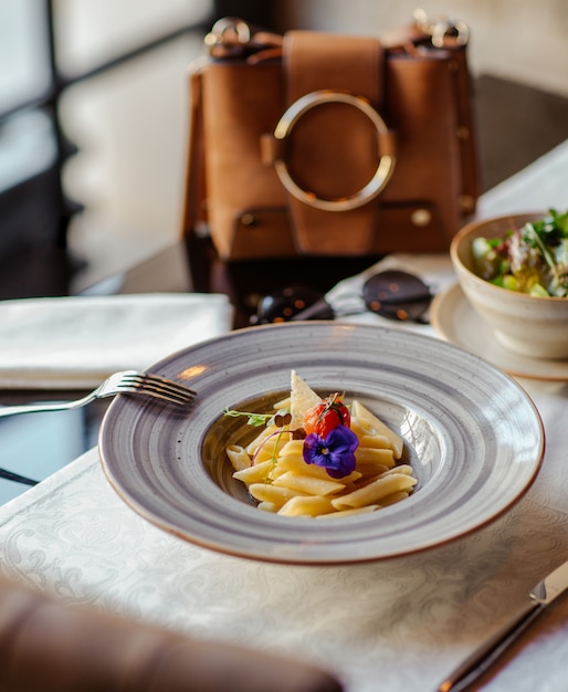 Pennedeegwaren met parmezaanse kaas in een ceramische plaat in een luxerestaurant