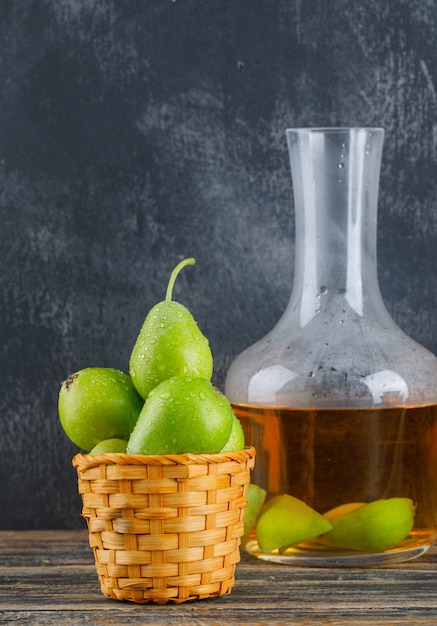 Peren in een mand met cider drinken zijaanzicht op houten en grungy muur