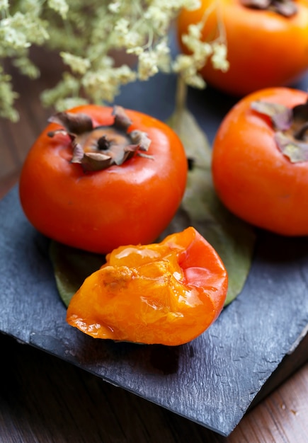 Gratis foto persimmons op steenplank