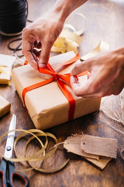 Persoon bindende strik op geschenkverpakking