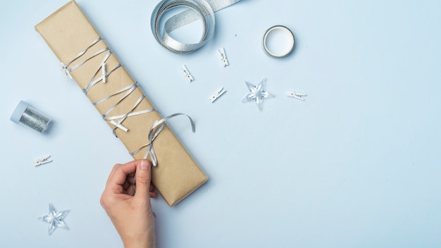 Gratis foto persoon bindende strik op grote geschenkdoos