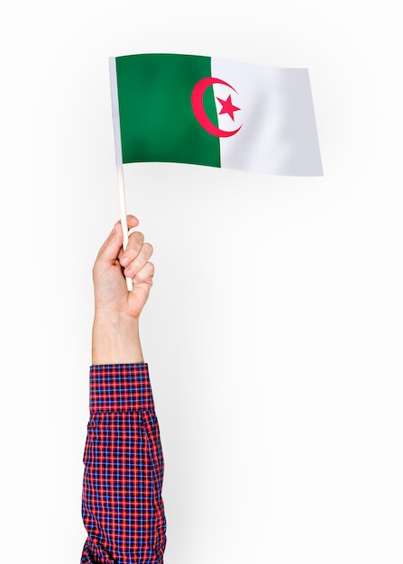 Persoon die de vlag van de Democratische Volksrepubliek Algerije zwaaien