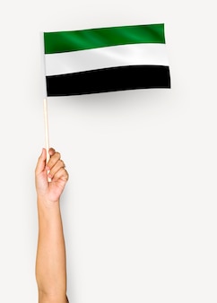 Persoon die de vlag van islamitische staat van afghanistan golft
