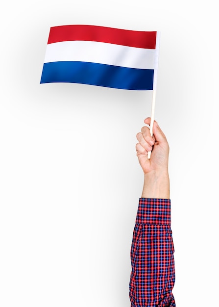 Gratis foto persoon die de vlag van nederland zwaaien