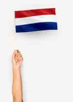 Gratis foto persoon die de vlag van nederland zwaaien