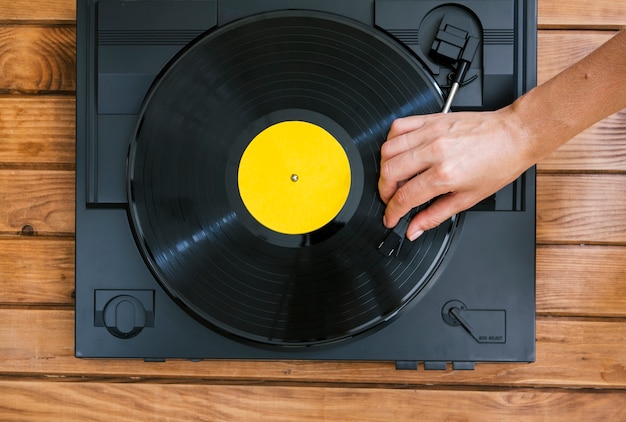 Persoon die een vinylschijf op uitstekende muziekspeler speelt