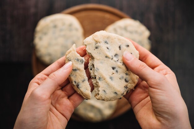 Persoon die gebroken koekje in handen houdt