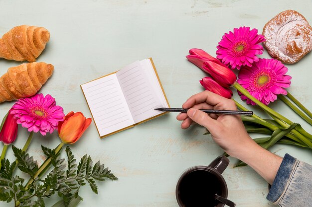 Persoon die in klein notitieboekje schrijft