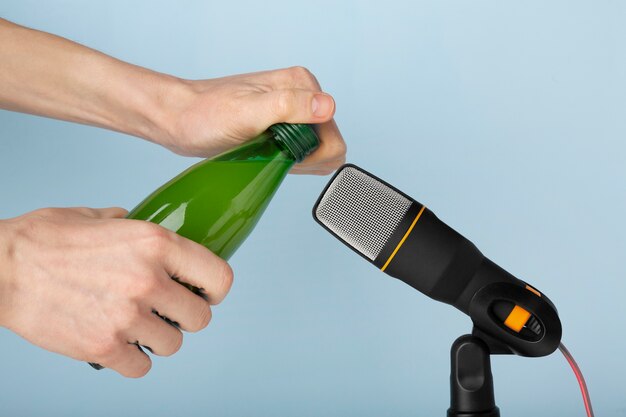 Persoon die plastic fles dicht bij microfoon gebruikt voor asmr