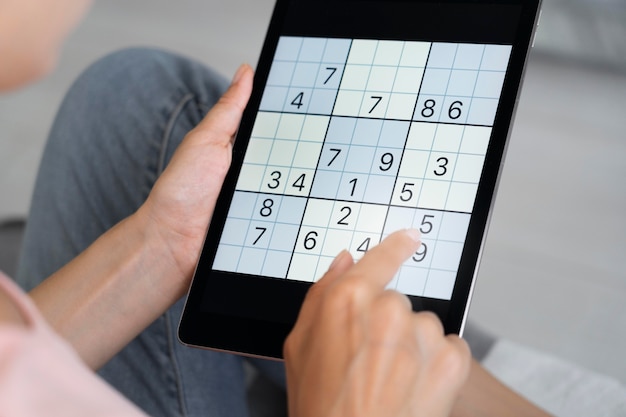 Persoon die sudoku speelt op een tablet