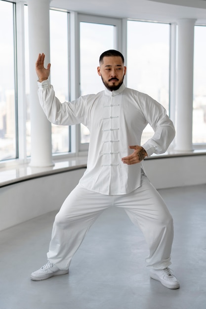 Gratis foto persoon die tai chi binnenshuis beoefent