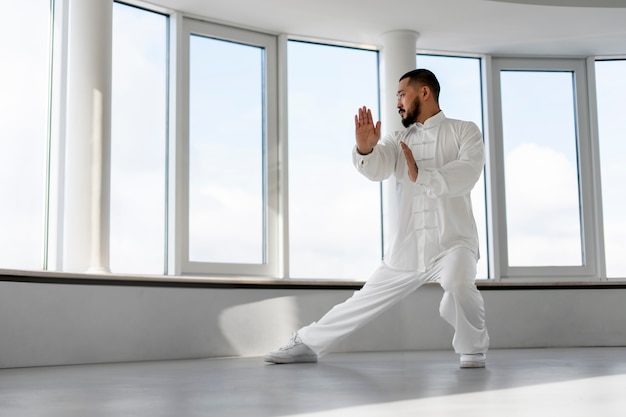 Gratis foto persoon die tai chi binnenshuis beoefent