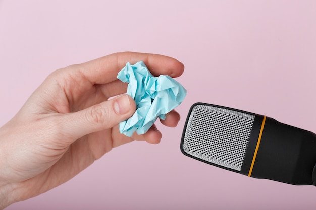 Gratis foto persoon die verfrommeld papier gebruikt in de buurt van microfoon voor asmr