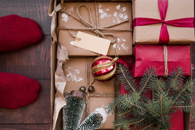 Persoon die zich op de vloer met geschenkdozen in kartonnen doos