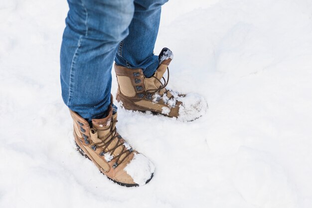 Persoon in laarzen die zich op sneeuw bevinden