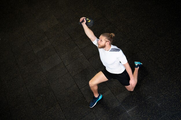 Persoon in sportgymnastiek die kettlebells gebruikt