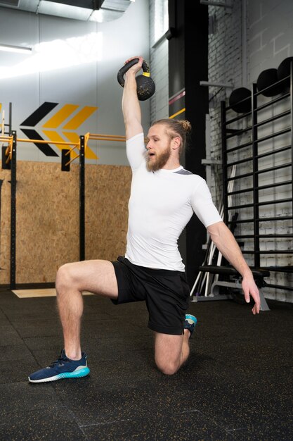 Persoon in sportgymnastiek die kettlebells gebruikt
