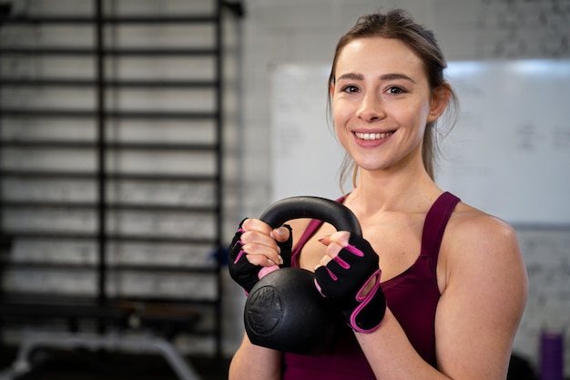 Gratis foto persoon in sportgymnastiek die kettlebells gebruikt