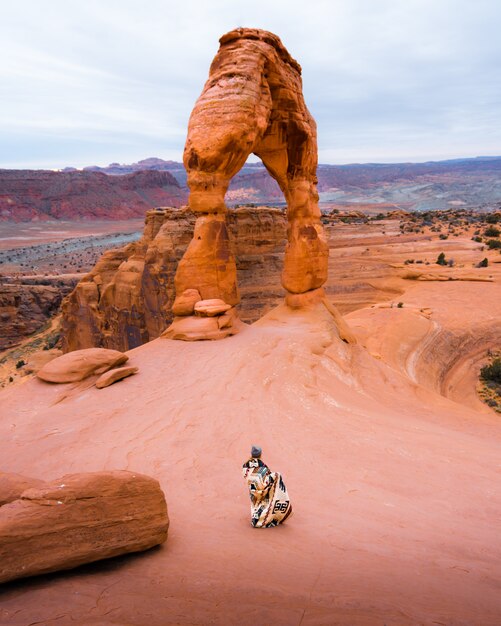 Persoon met een deken die zich voor de mooie Grand Canyon-rotsen bevindt