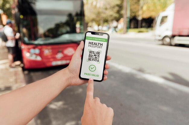 Persoon met virtueel gezondheidspaspoort op smartphone bij het busstation