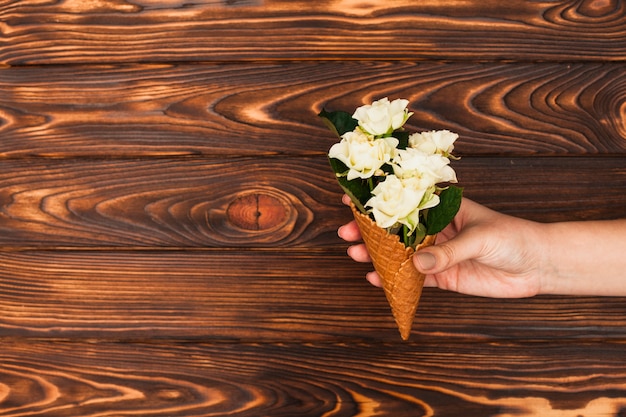 Persoon met wafel kegel met witte rozen