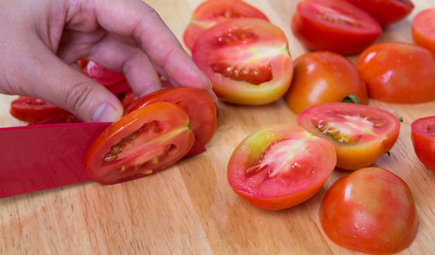 Gratis foto persoon snijden gesneden tomaten