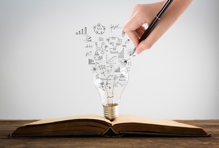 Gratis Foto persoon tekening symbolen coming out van een gloeilamp op de top van een boek